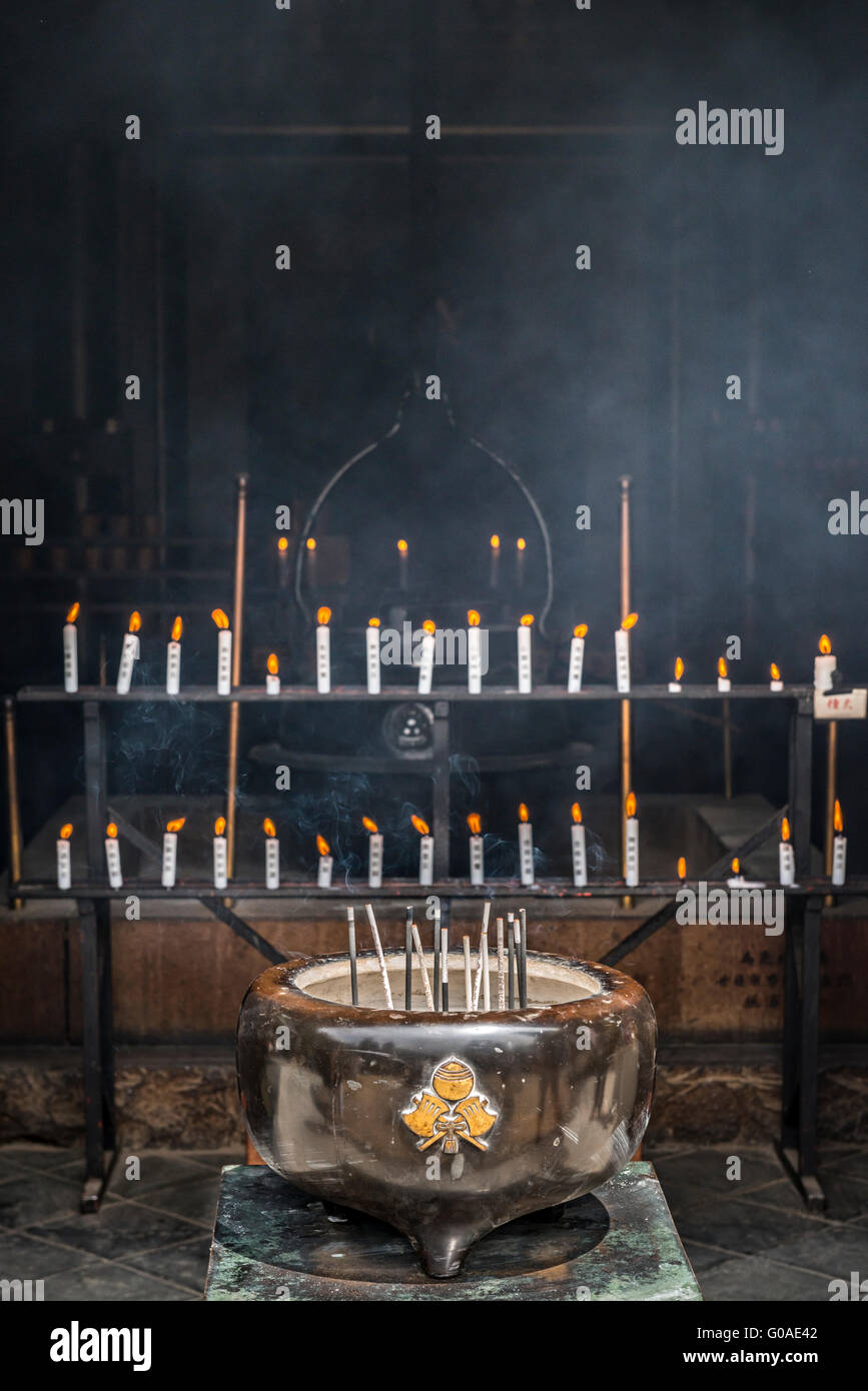 Incense and candles burn infront of the eternal flame in the Reikado