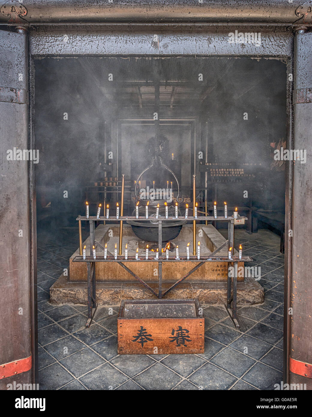 Incense and candles burn infront of the eternal flame in the Reikado