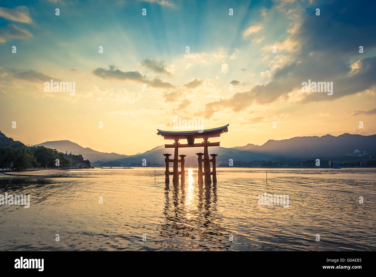 The sun sets behind the floating Torii gate at the Itsukushima Shrine on Miyajima Stock Photo