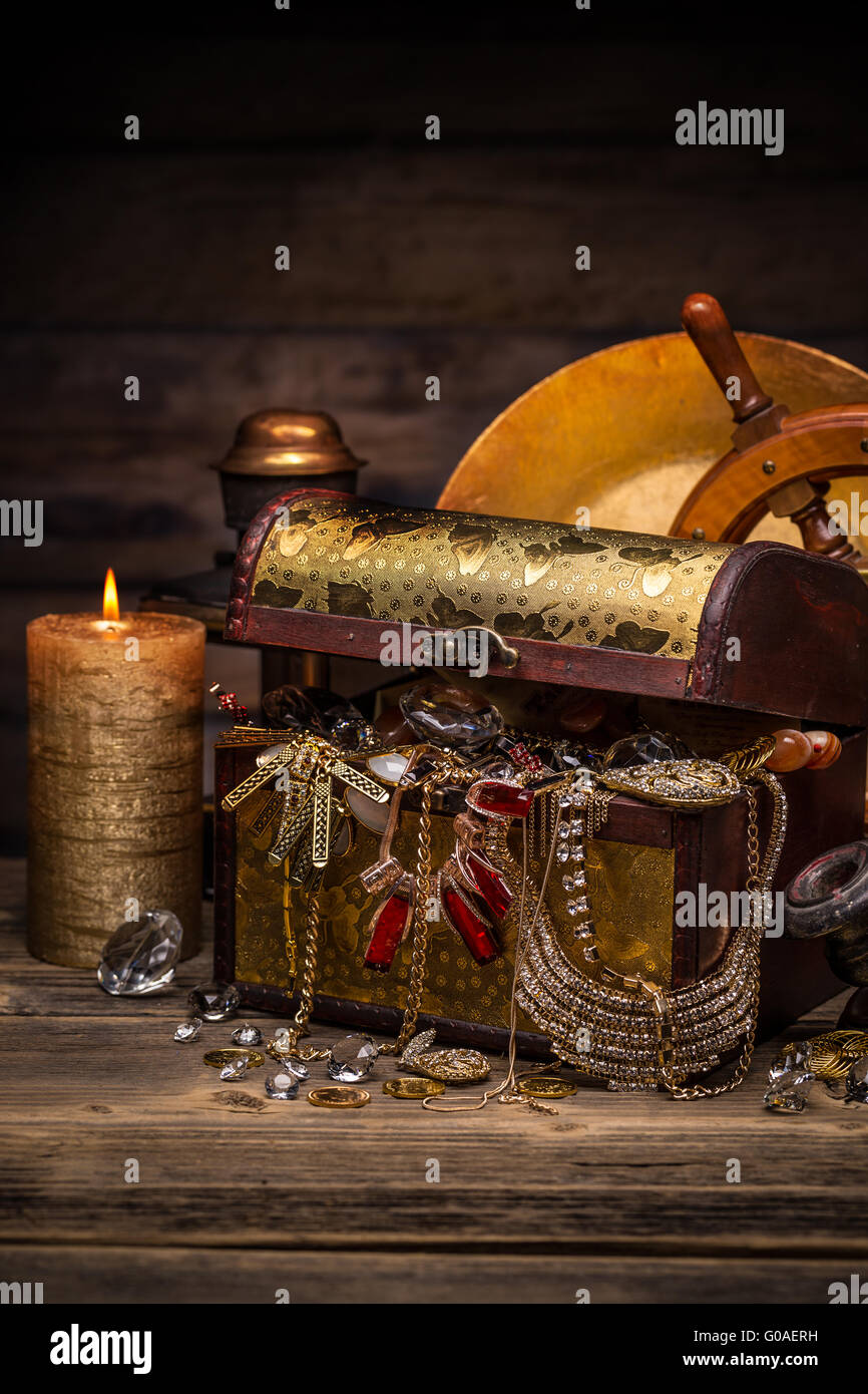 Old wooden open chest with golden jewelry Stock Photo