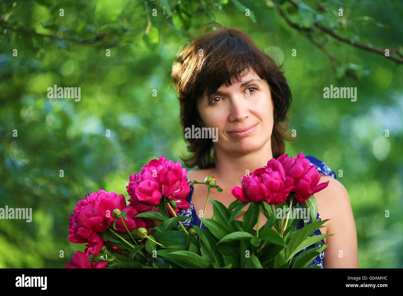 woman  in a garden with  bunch of flowers soft focus Stock Photo