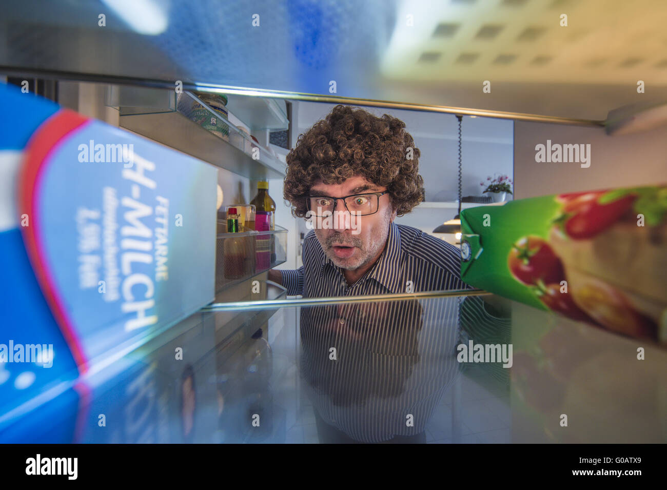 A shocked man looking in refrigerator beer Stock Photo