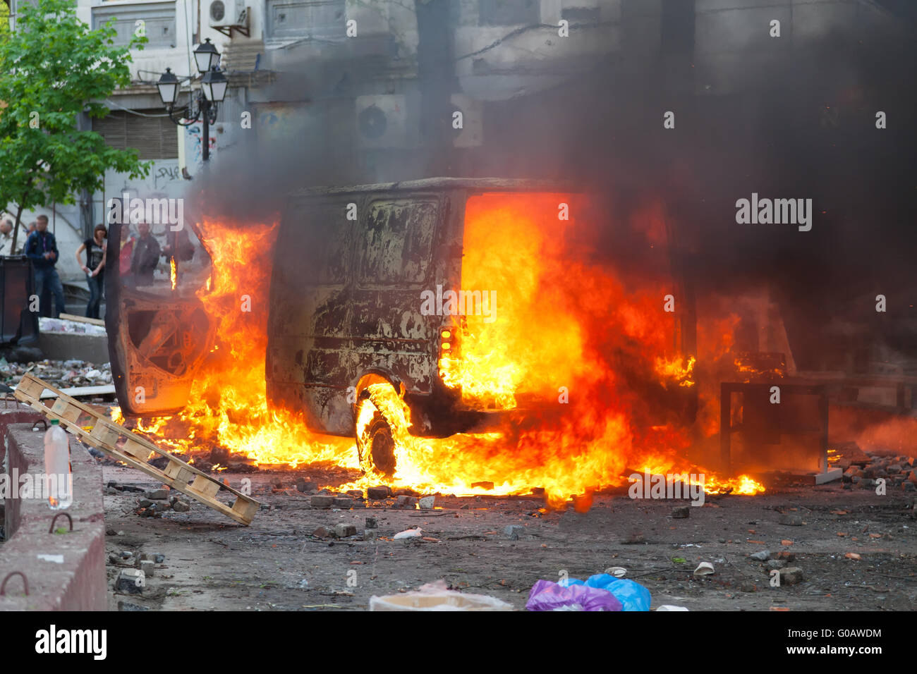 Burning car in the center of city during unrest Stock Photo