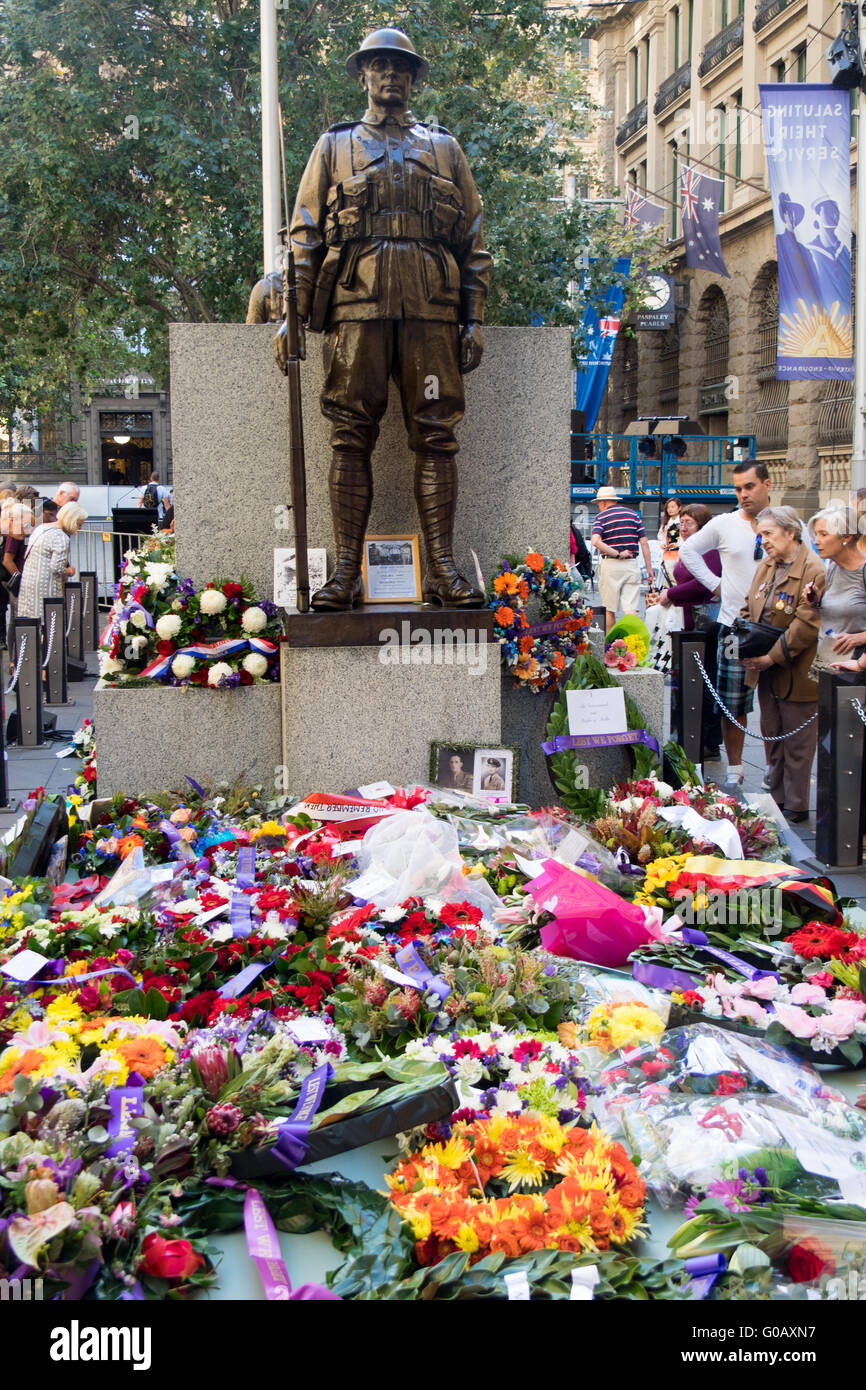 Wreaths,on ANZAC Day, laid out in front of a bronze statue and cenotaph commemorating the fallen