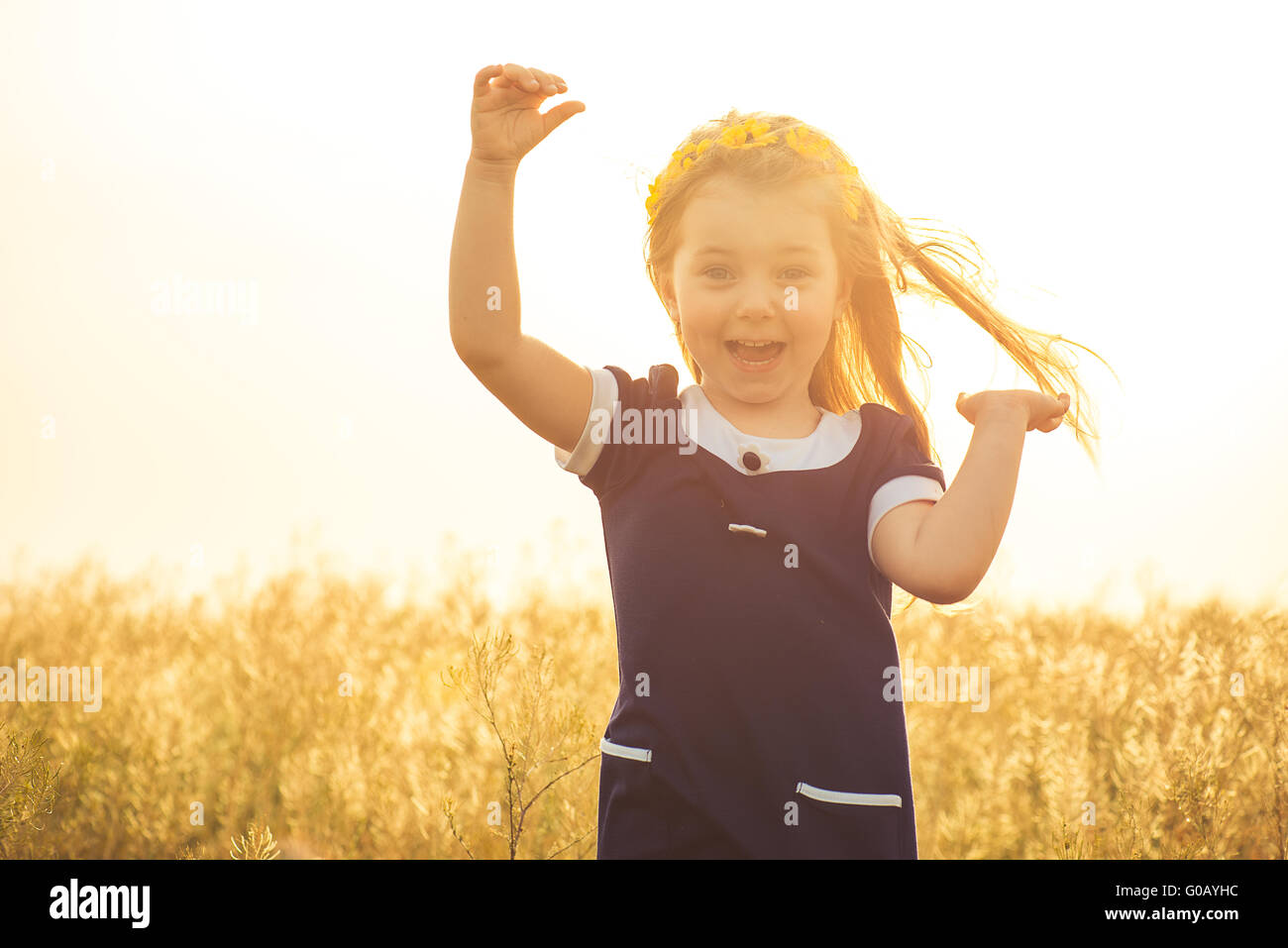 the beautiful little girl in a blue dress laughs Stock Photo - Alamy