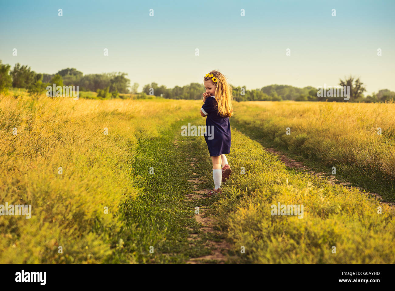 the beautiful little girl in a blue dress laughs Stock Photo - Alamy
