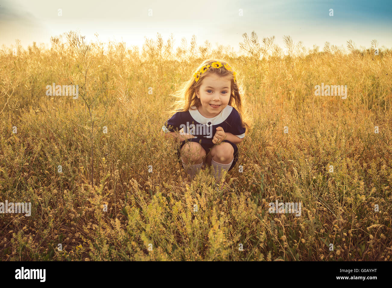 the beautiful little girl in a blue dress sitting Stock Photo - Alamy
