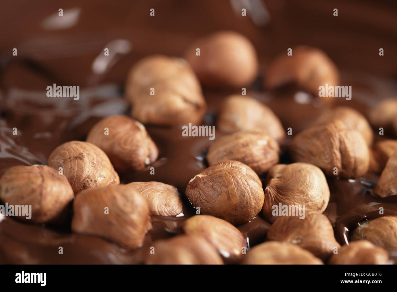 melted dark chocolate with hazelnuts, making chocolate bar Stock Photo