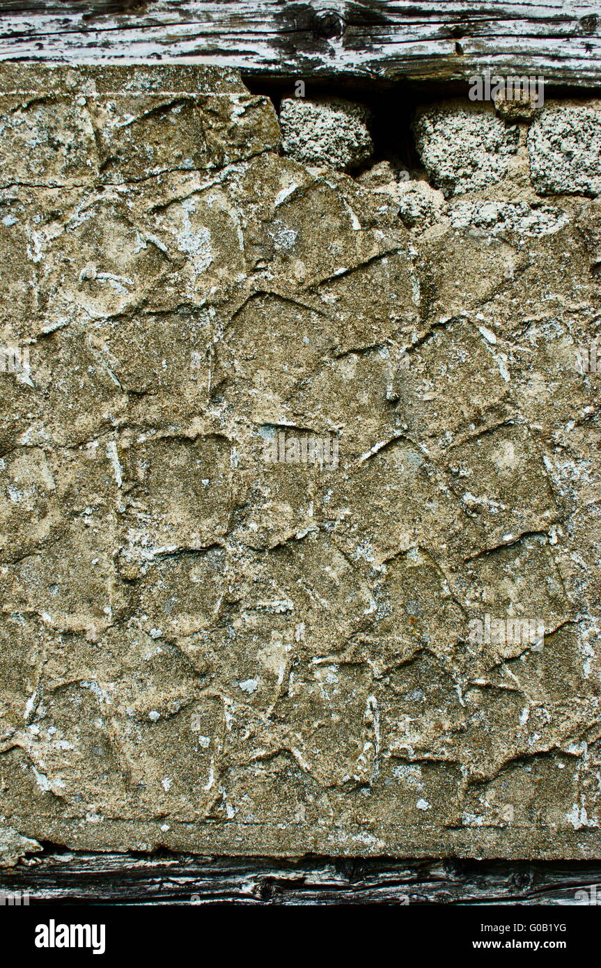 Weathered exterior wall surface with exposed wood Stock Photo
