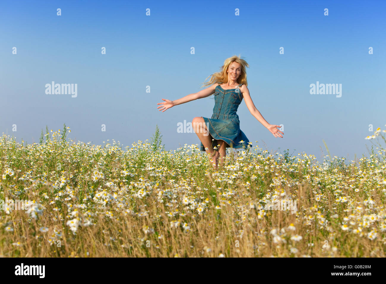 The beautiful happy young woman in the field of ch Stock Photo