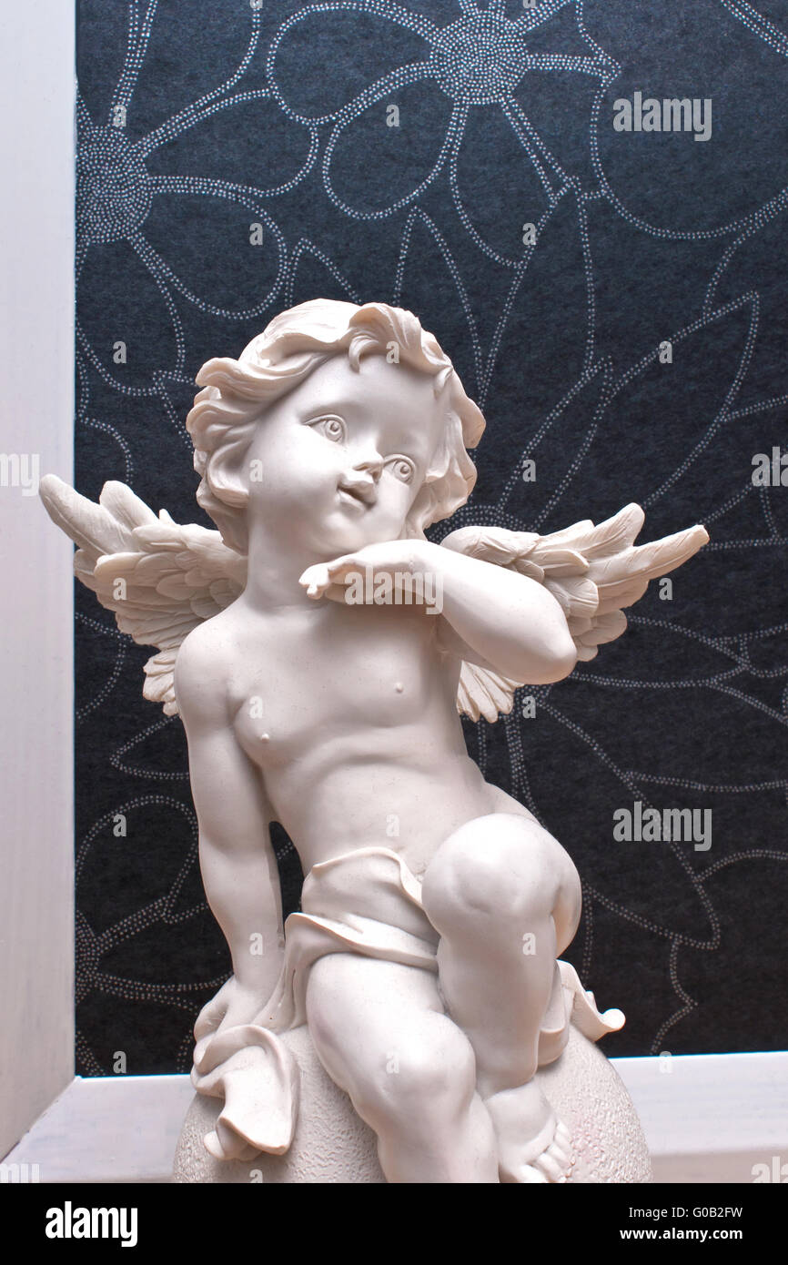 Upper body of a white angel figure in front of a d Stock Photo
