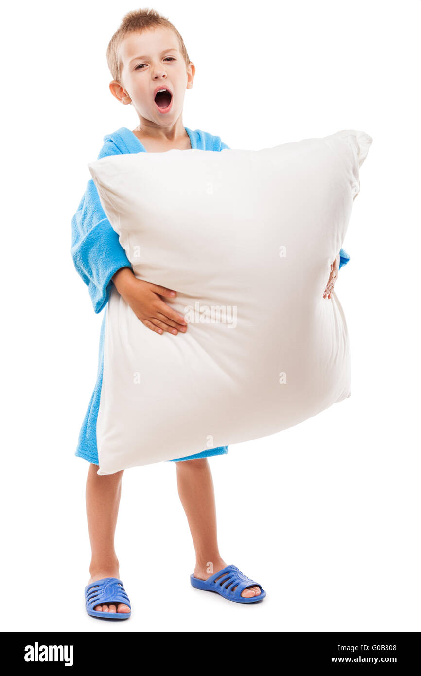 Yawning child boy holding pillow going to sleep Stock Photo