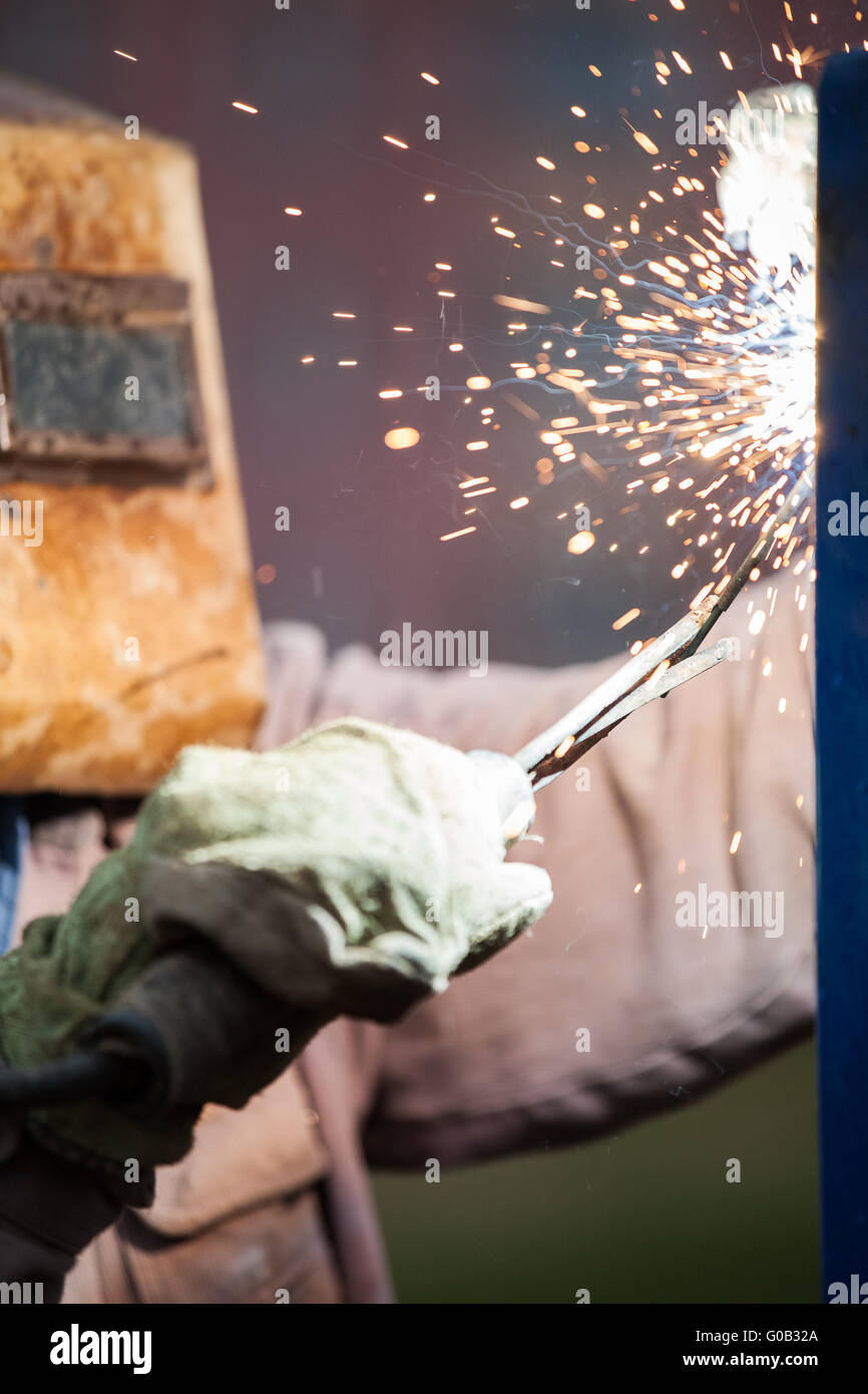 Arc welder worker in protective mask welding metal Stock Photo