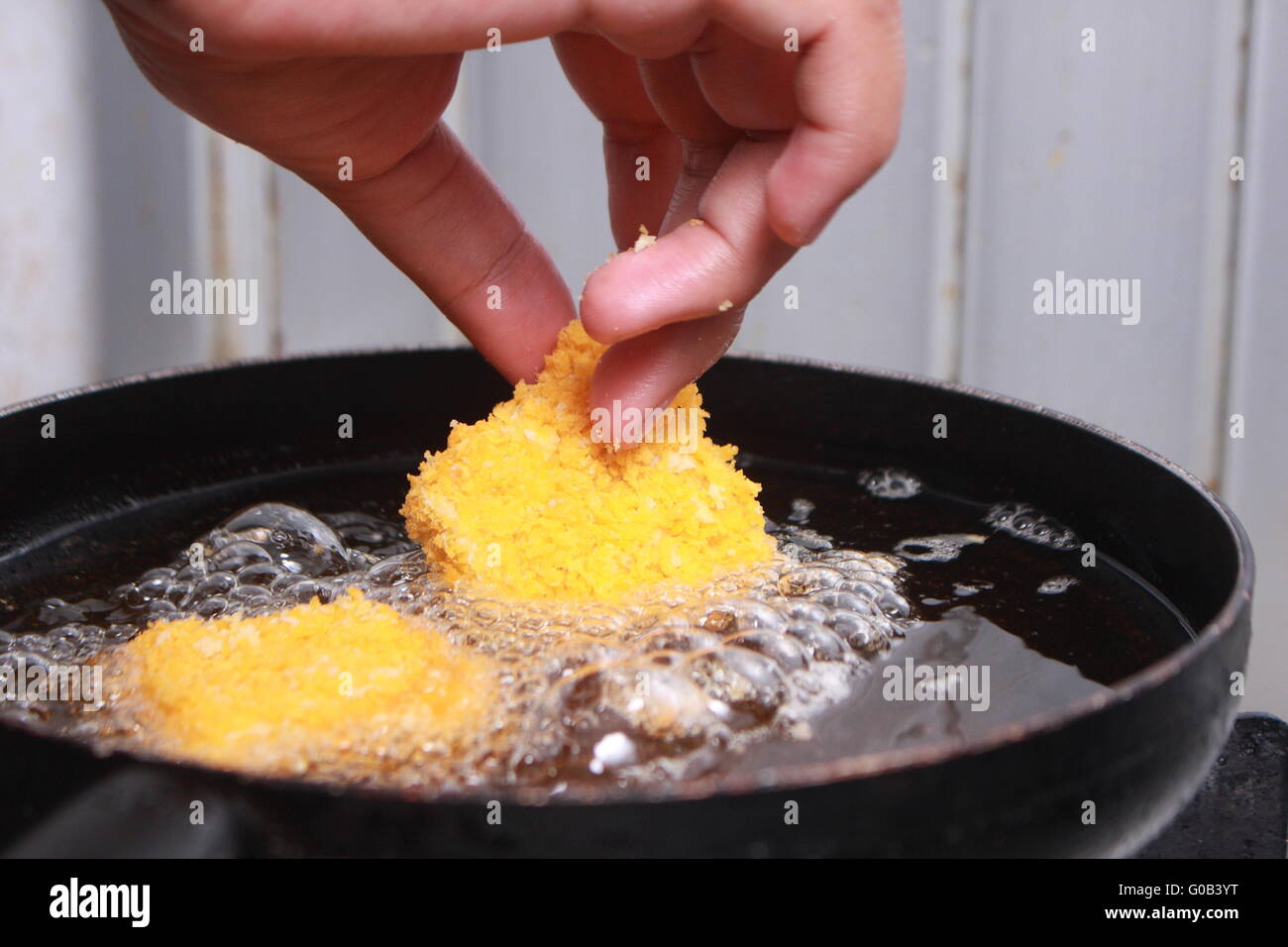 Close up image of chef hand putting chicken nuggets tempura in to hot