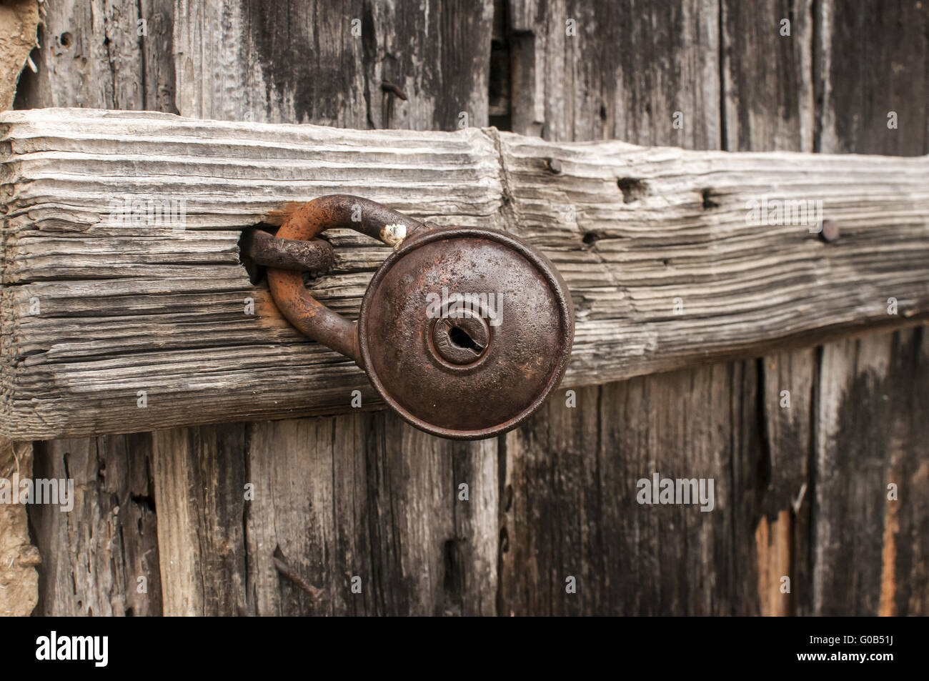 Old rusty padlock on weathered wooden door closeup Stock Photo - Alamy