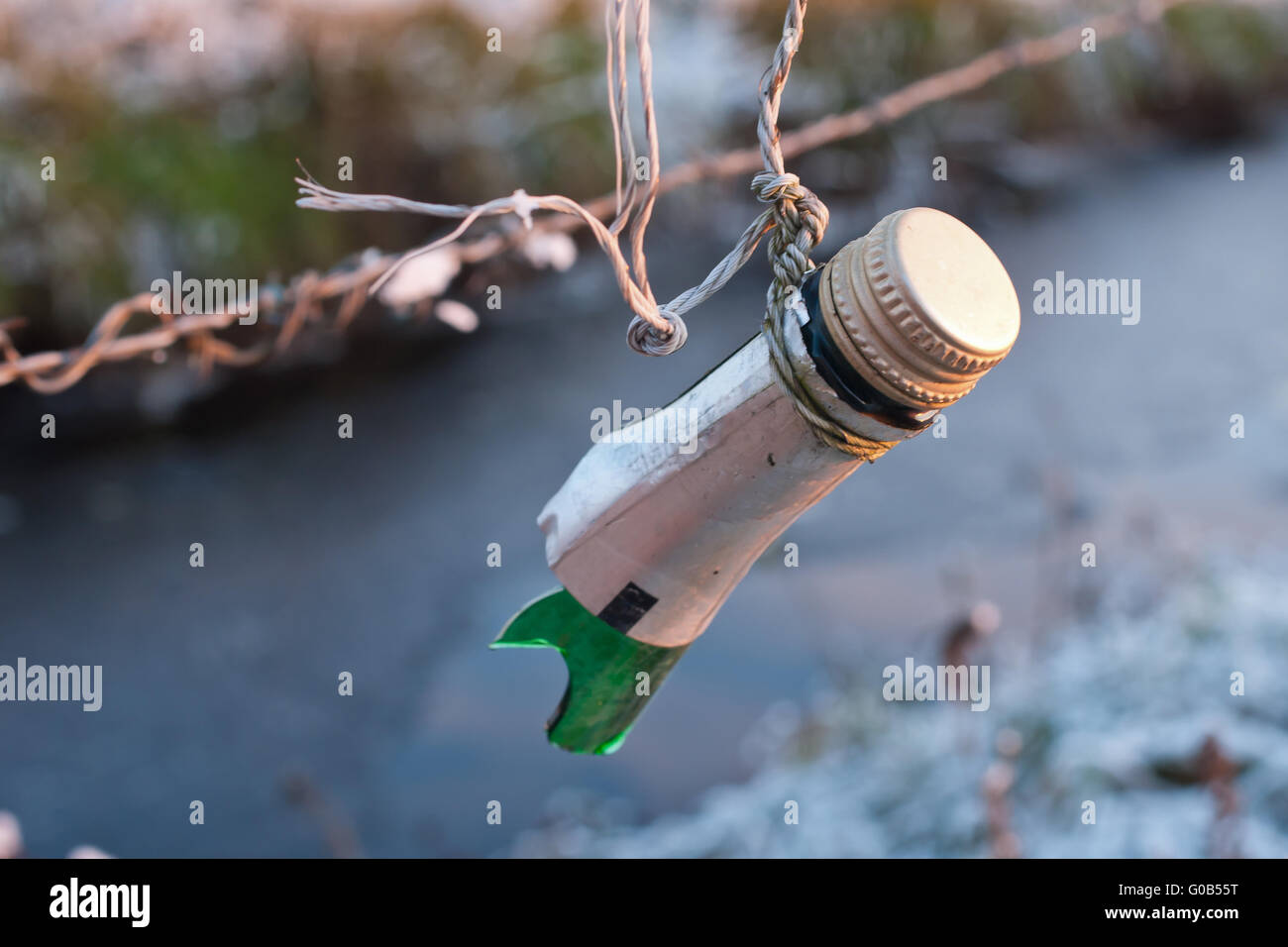 upper part of a broken bottle at a cattle-fence Stock Photo