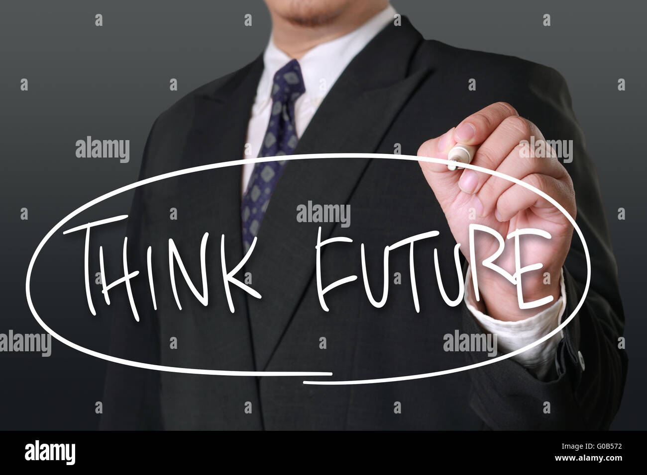 Motivational business concept, image of a businessman holding marker and write Think Future words Stock Photo