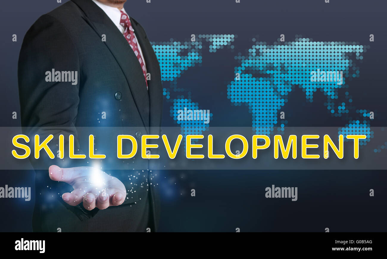 Business concept image of a businessman showing Skill Development words on his hand over blue background with dotted world map Stock Photo