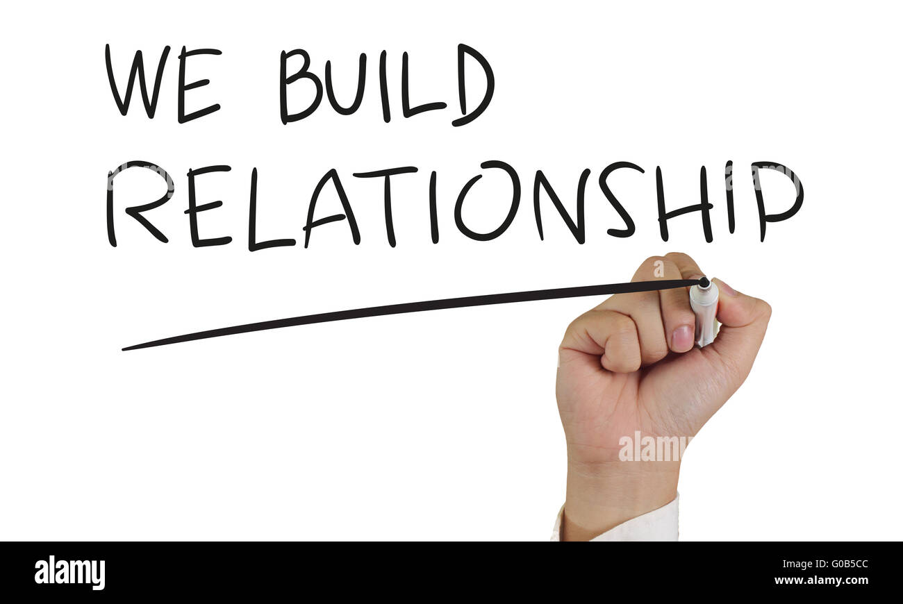 Motivational concept image of a hand holding marker and write We Build Relationship isolated on white Stock Photo