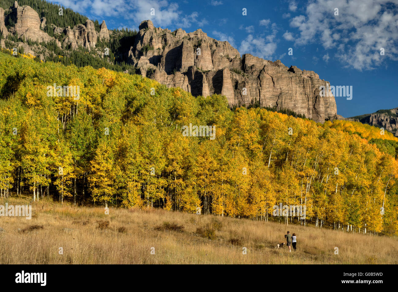 A couple and their dog enjoy a magnificent Colorado autumn in the San Juan mountains near Silverjack Lake. Stock Photo