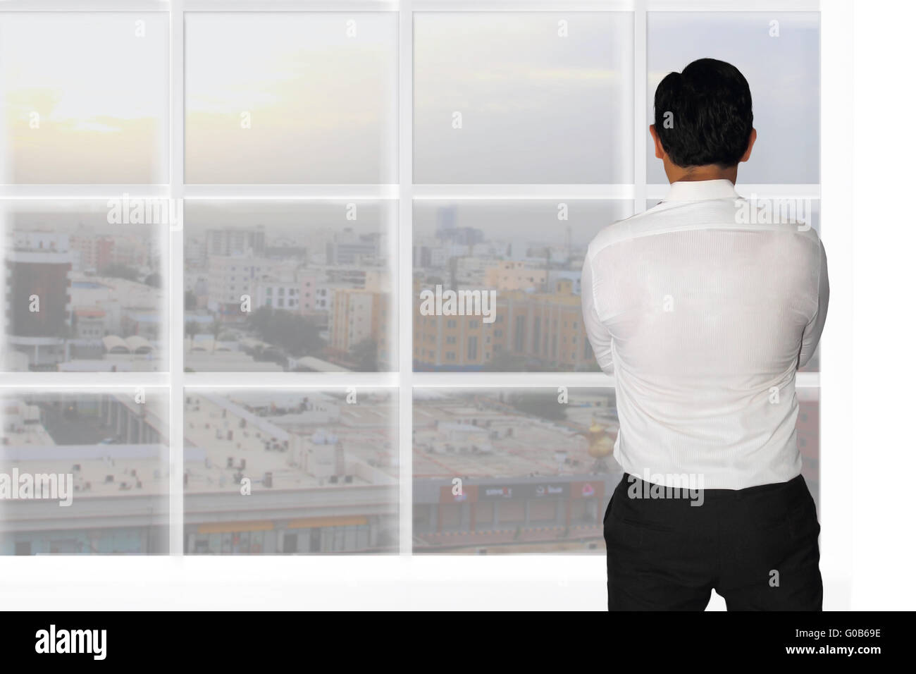 Vision concept image rear view of a businessman starring outside window looking at opportunities Stock Photo