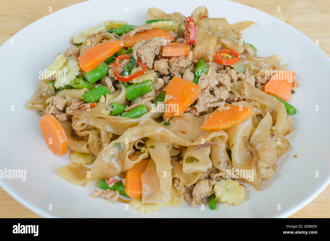 Stir Fried Flat Rice Noodles With Pork Basil And Cow pea Stock Photo stir-fried-flat-rice-noodles-with-pork-basil-and-cow-pea-stock-photo