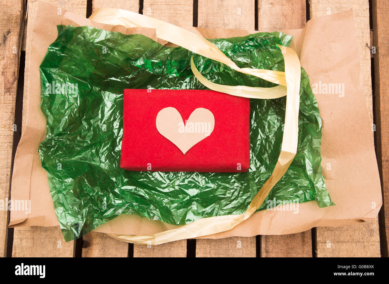 Red Present String Red present lying on green plastic with golden ribbon string around it ...