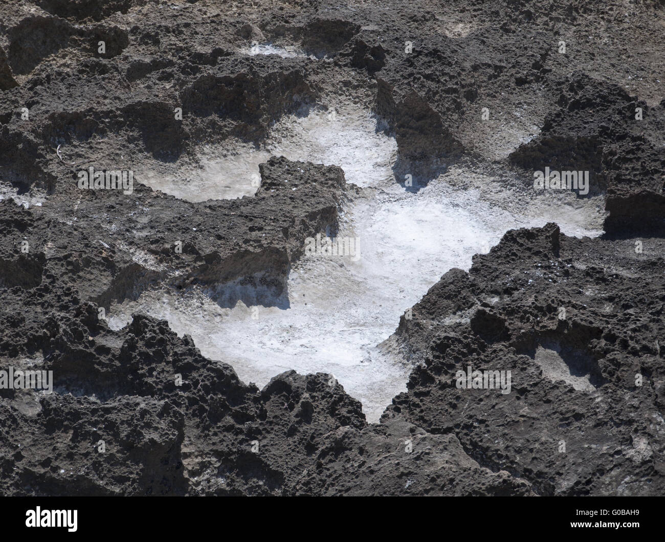 Salt precipitation in eroded black oxidized limest Stock Photo