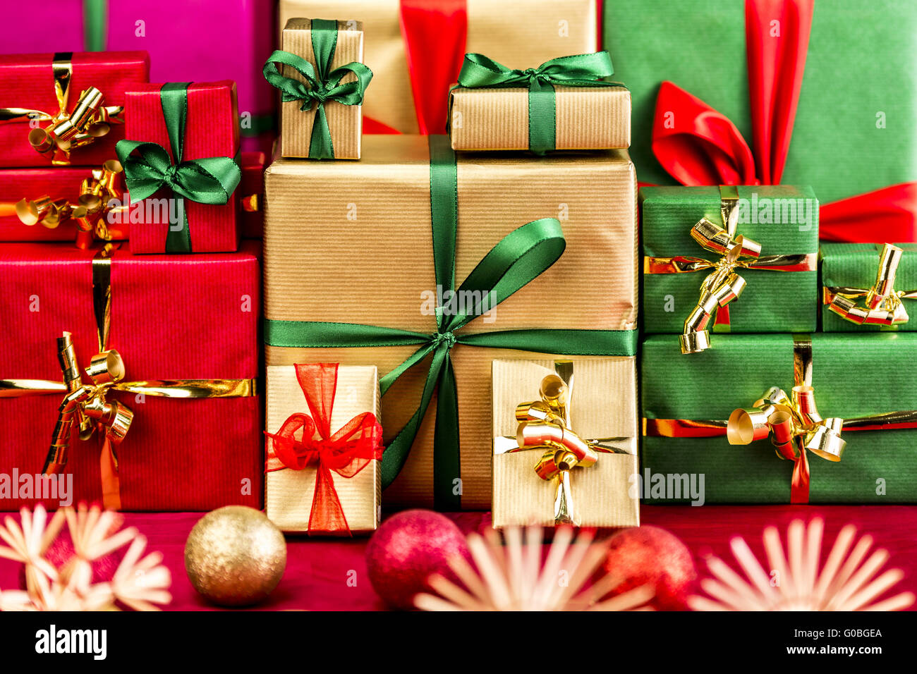 Three Piles of Xmas Gifts in Red, Gold and Green Stock Photo