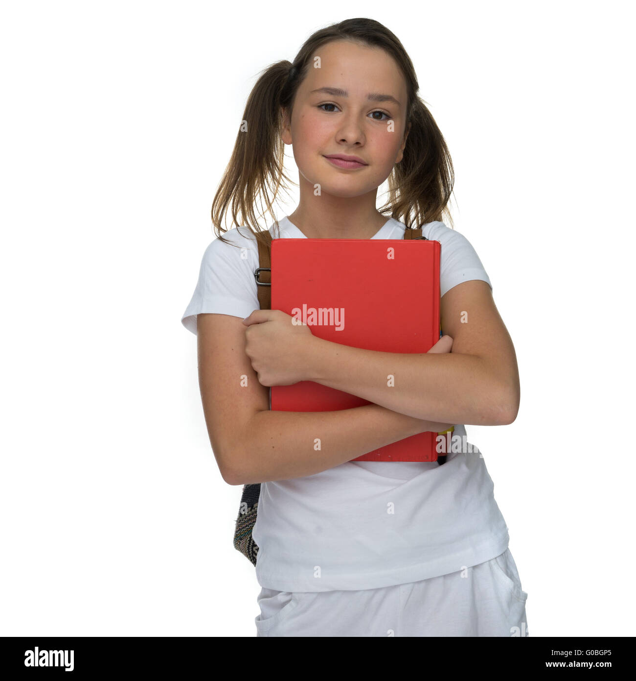 Young schoolgirl clutching a text book Stock Photo