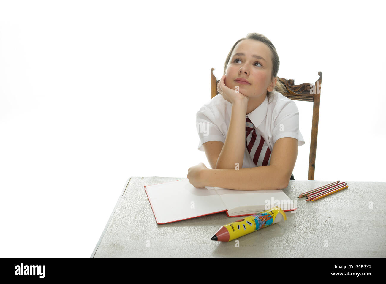 Bored young schoolgirl sitting daydreaming Stock Photo - Alamy