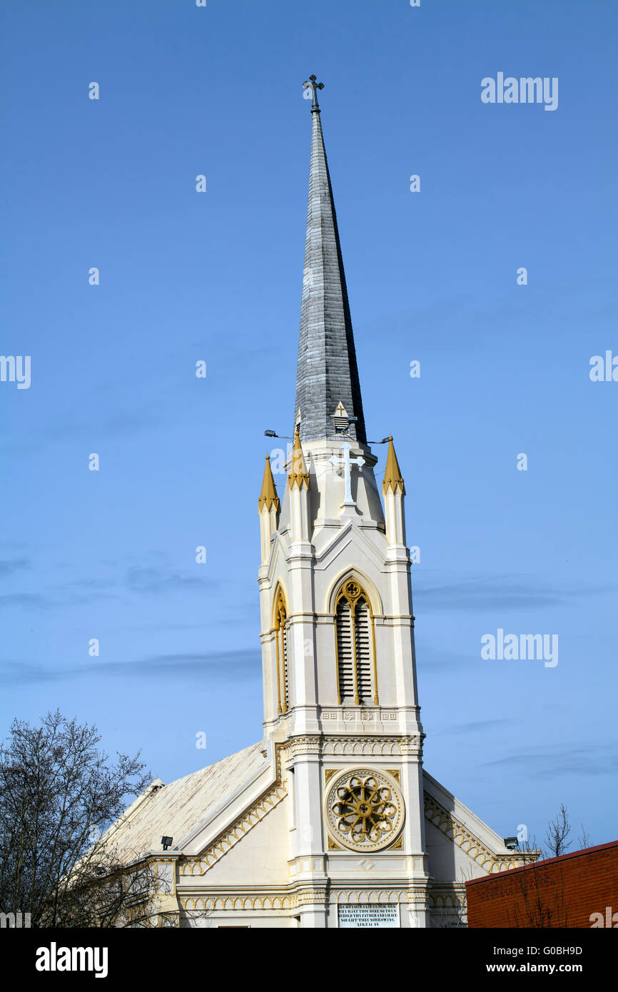 upper part of old church with steeple on blue sky Stock Photo