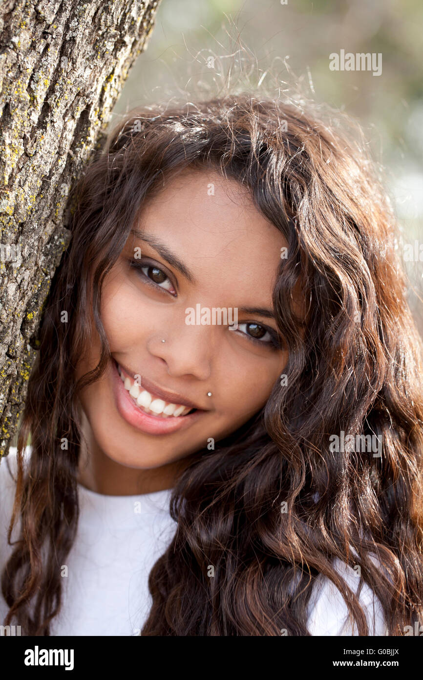 Young Latina teen girl smiling portrait oak tree Stock Photo