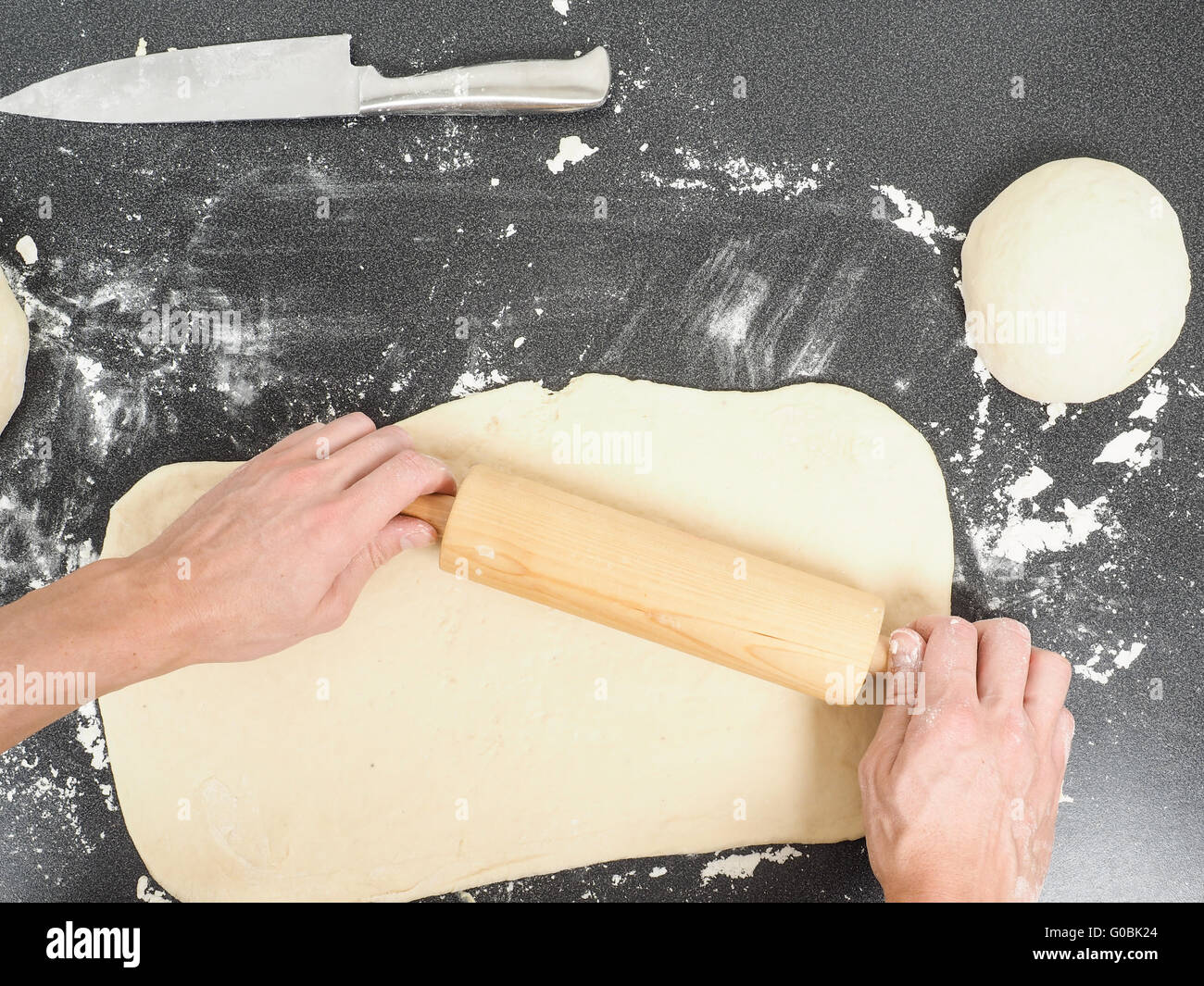 Hands handling dough with rolling pin Stock Photo