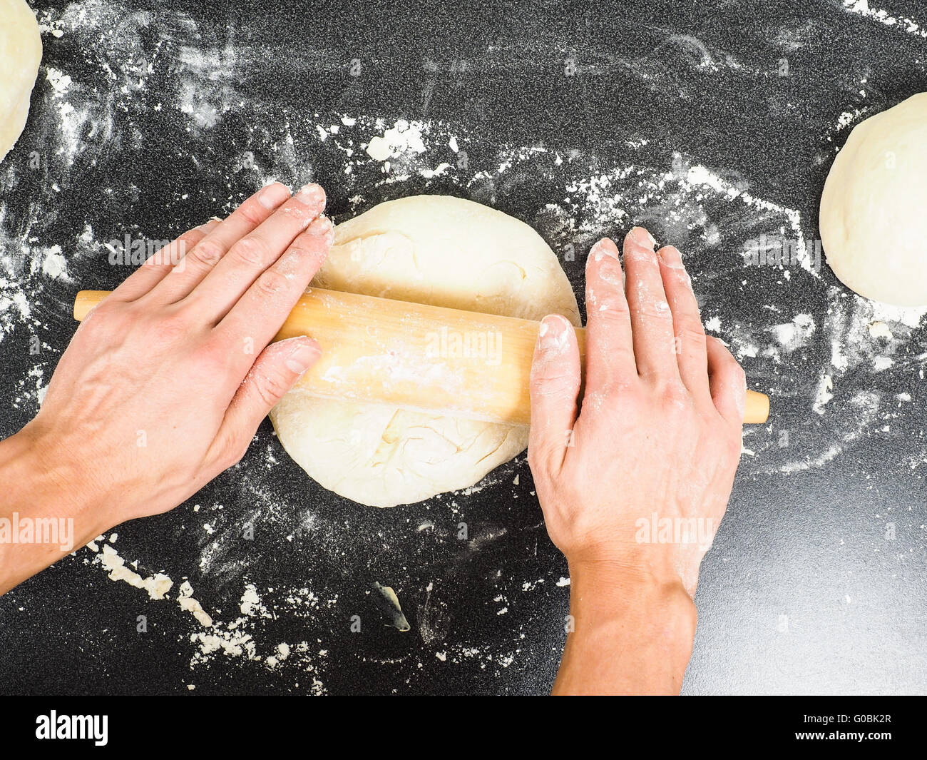 Hands handling dough with rolling pin Stock Photo