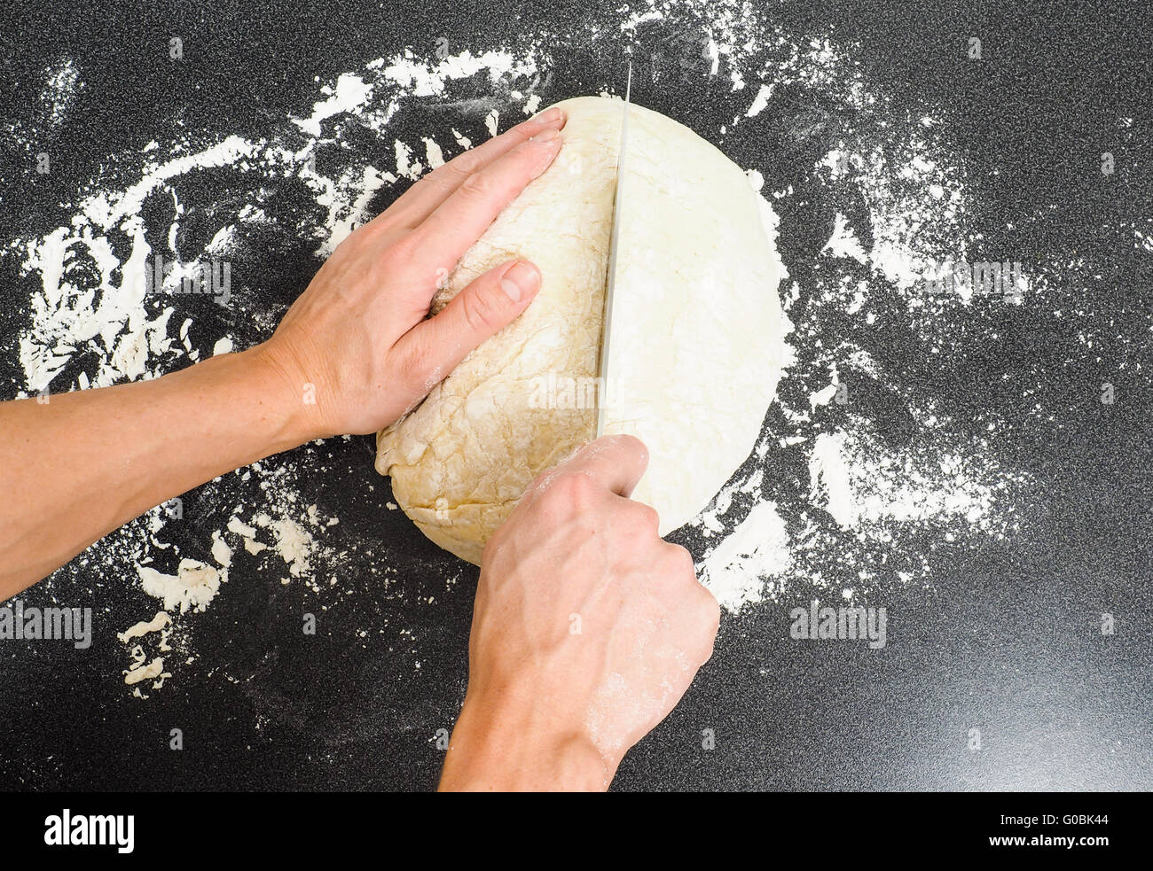 Hands cutting dough with knife Stock Photo Alamy