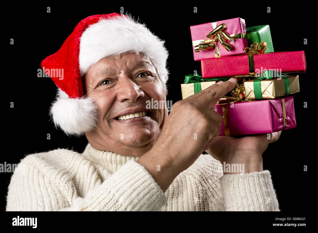 Male Senior Firmly Pointing At Six Wrapped Gifts Stock Photo