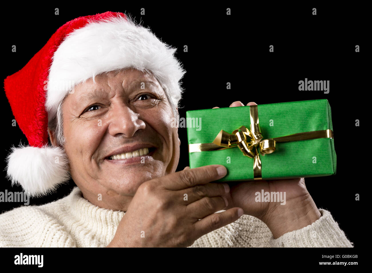 Elderly Man with Santa Cap And Green Wrapped Gift Stock Photo
