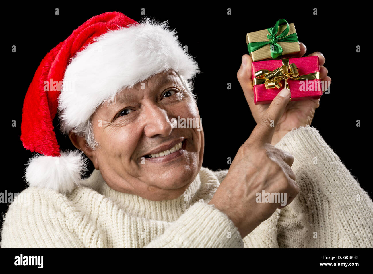 Smiling Senior Pointing At Two Wrapped Xmas Gifts Stock Photo
