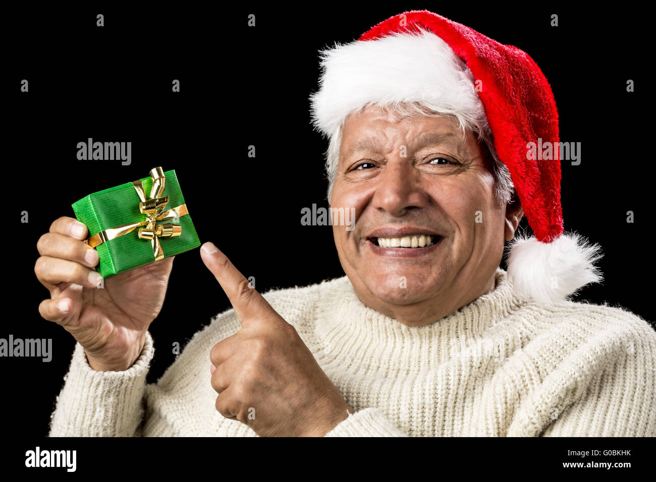 Cheerful Old Man Pointing At Green Wrapped Gift Stock Photo