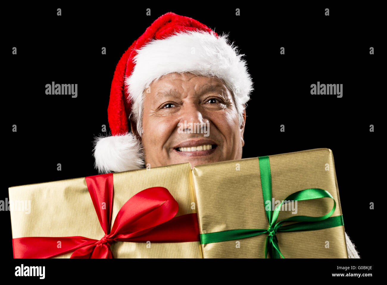 Smiling Aged Man Peeking Across Two Golden Gifts Stock Photo