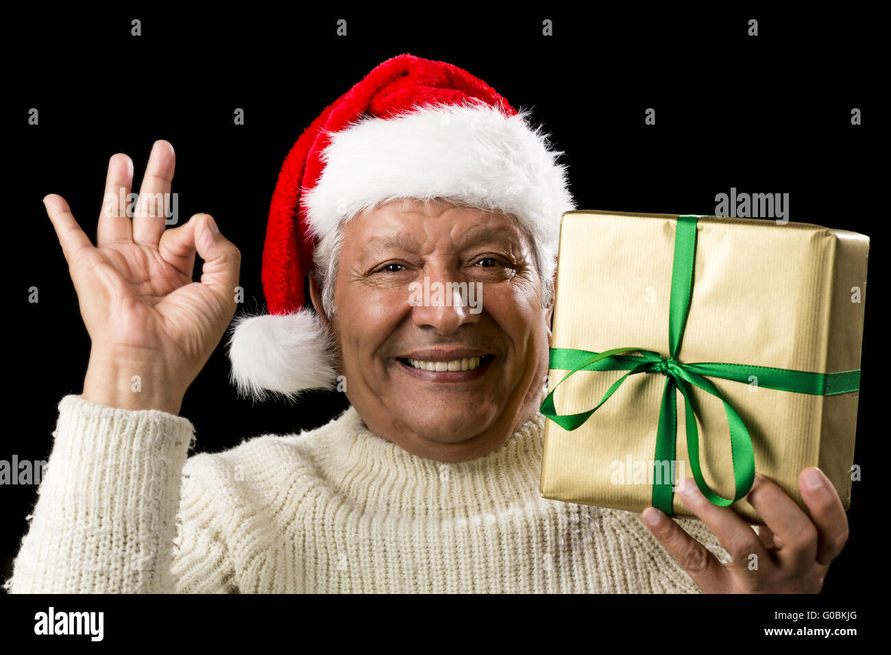 Grinning Male Senior With Gift Gesturing OK Sign Stock Photo