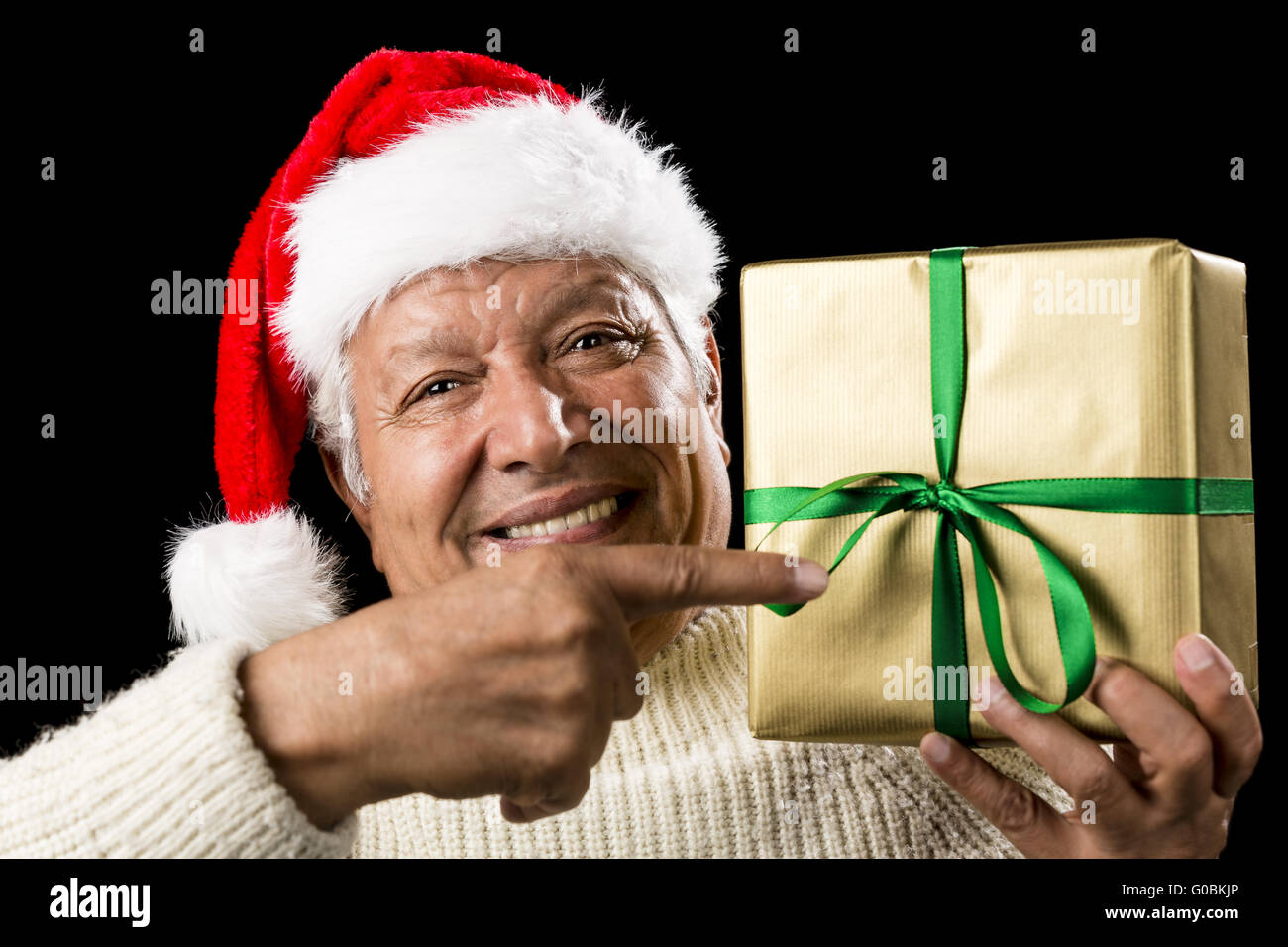 Broadly Grinning Aged Male Pointing At Golden Gift Stock Photo