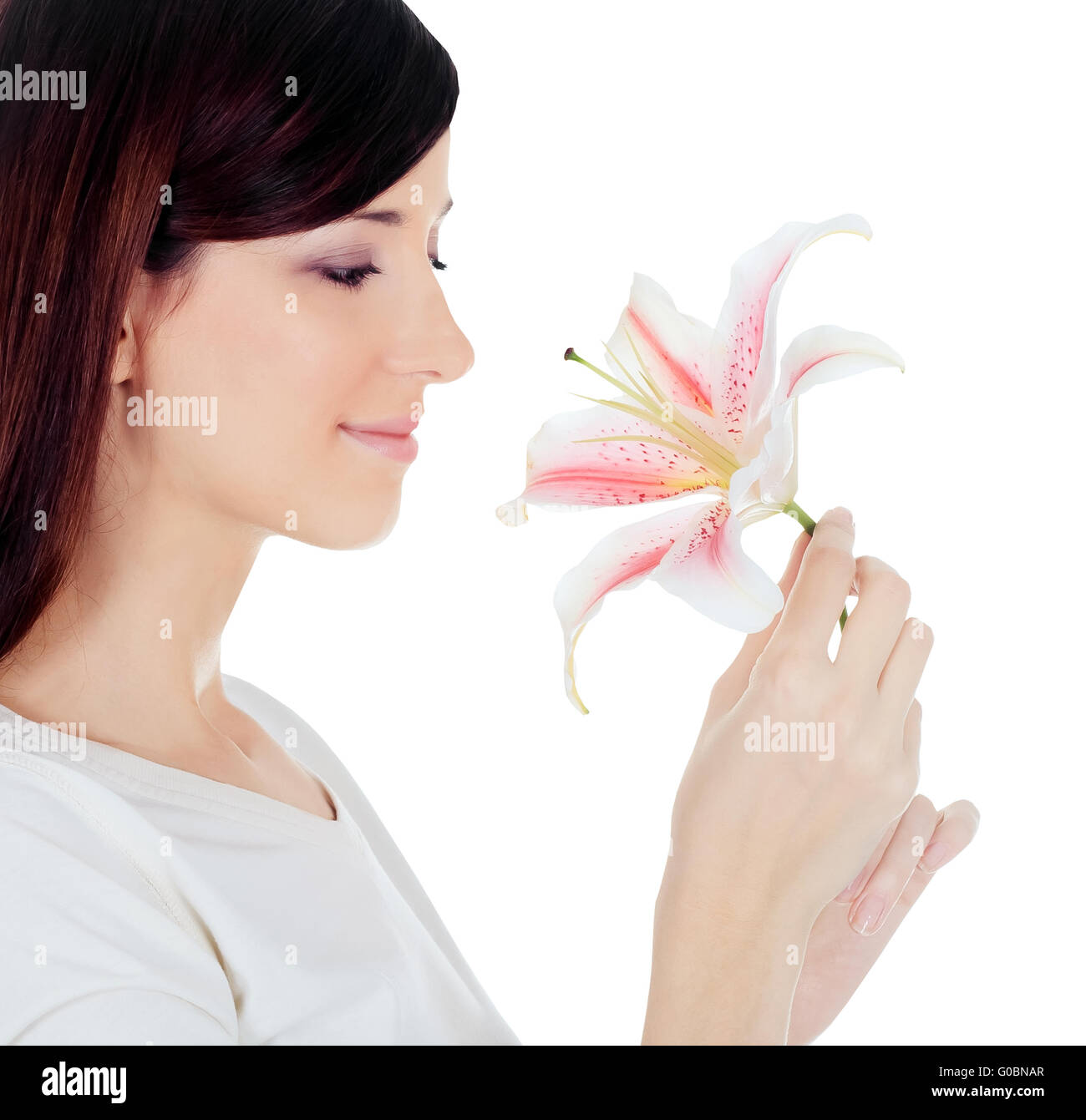 Beautiful young woman holding a white lily at face isolated over white Stock Photo