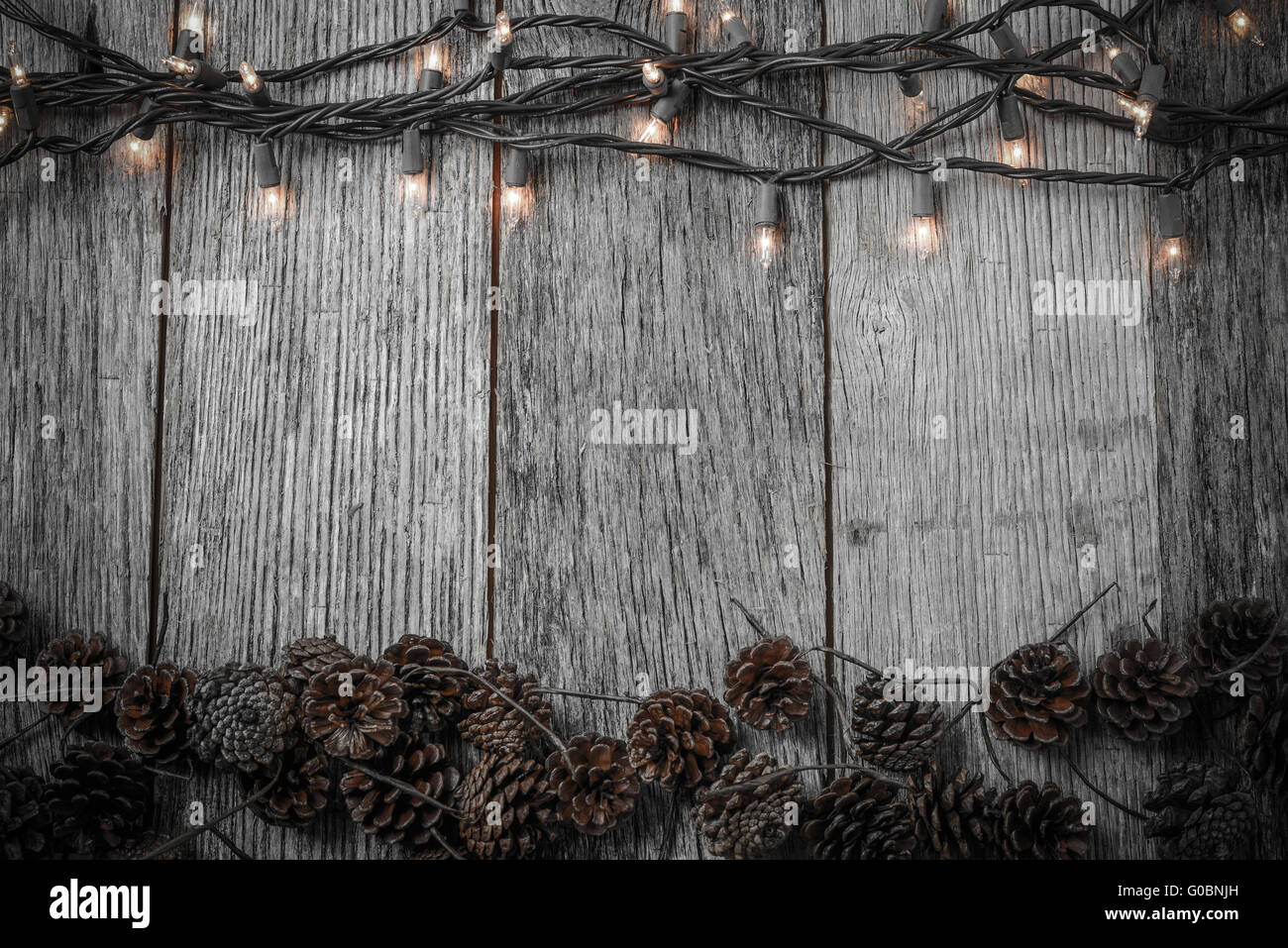 Christmas Lights and Pine cones on Rustic Wood Background Stock Photo