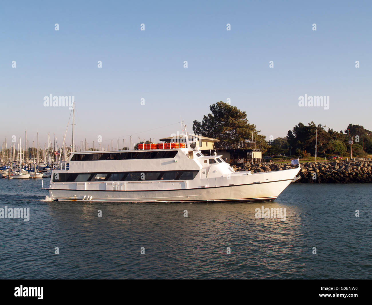 White motor yacht heading out of marina Stock Photo - Alamy