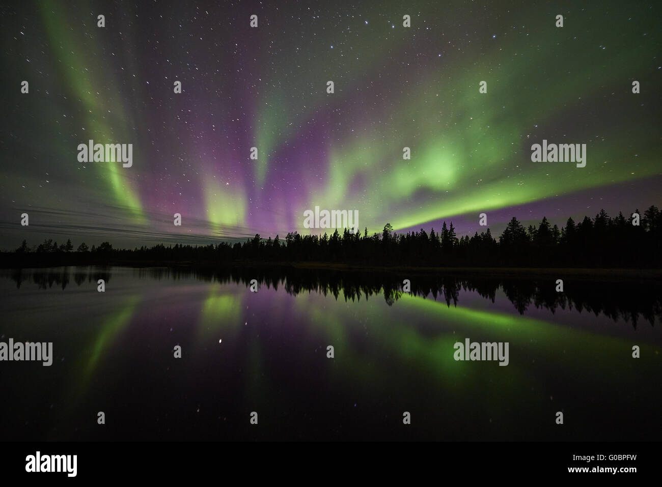 Northern lights reflecting in a lake, Lapland Stock Photo