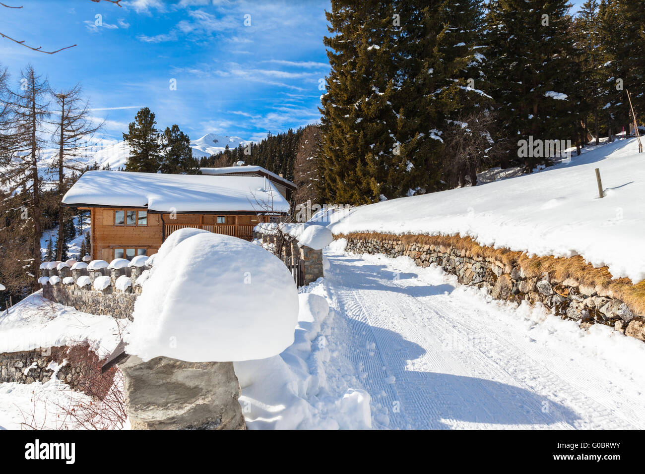 Beautiful view of wooden house with snow covered roof in winter, Davos, Switzerland. Stock Photo