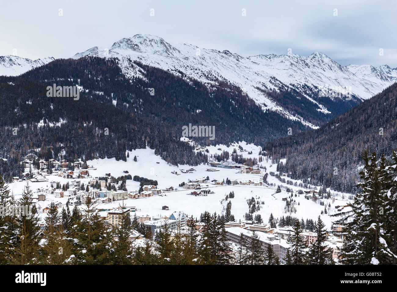 Aerial view of Davos in Winter with snow covered roofs and the Alps