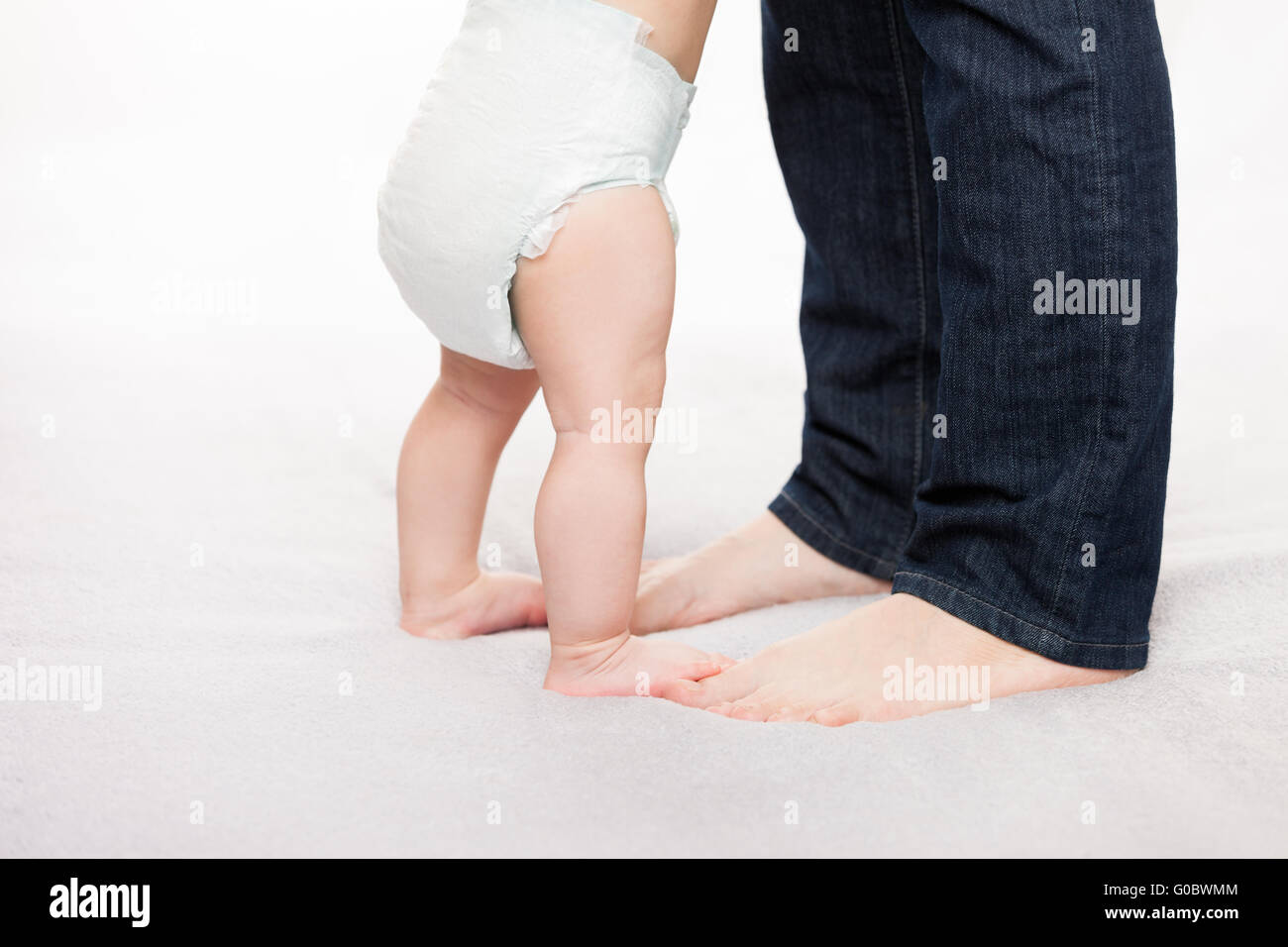 Mother holding little baby child boy making first Stock Photo